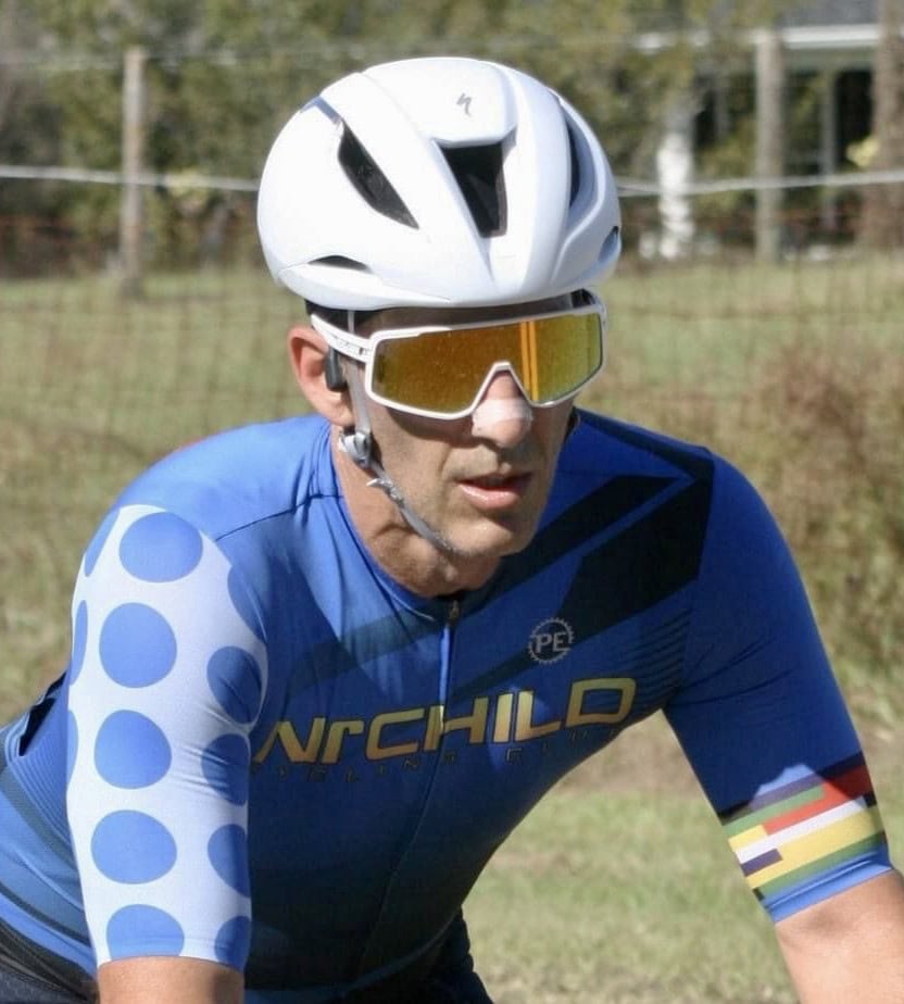 A man in a bike helmet looks serious.